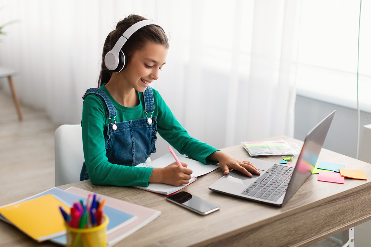 Young girl listening to an ELT ebook on a laptop - ELT and e-learning audio production