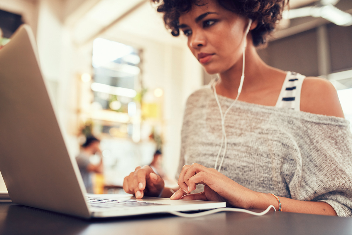 Young woman listening to e-learning content on a laptop - ELT and e-learning audio production